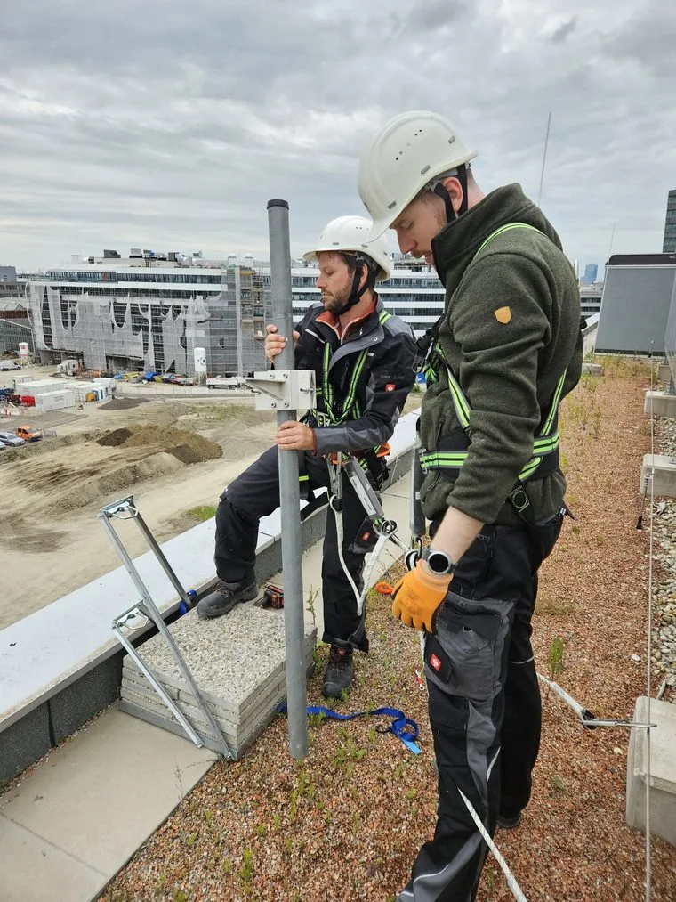 Team installing a camera on a roof with the Vienna skyline